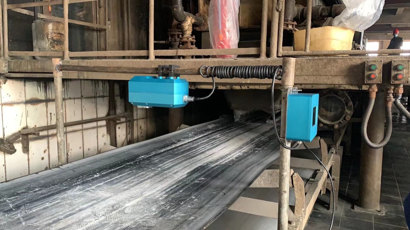 ALZRO NIR moisture analyzer mounted above conveyor — lens facing downward toward material